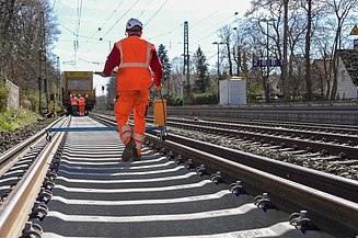 Pracovníci v reflexním oblečení při stavebních pracích na železniční trati