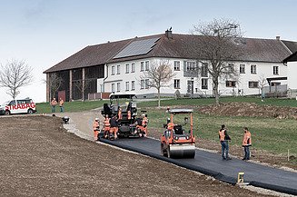 Az aszfalt újrahasznosítása mint a körforgásos gazdaság egyik aspektusa az építőiparban Fotó az újrahasznosított aszfalt beépítéséről egy útelágazásnál, mint a sikeres körforgásos gazdaság példája az építőiparban