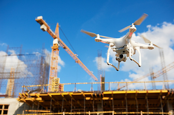 Foto einer Drohne die über eine Baustelle fliegt