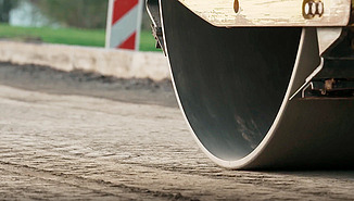 Close-up of a roller compacting the road surface