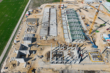 Aerial view of the construction site of an electrolysis plant with cranes and shell construction in Bruck an der Leitha