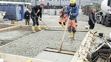 Fotografie de muncitori în construcții care toarnă beton durabil