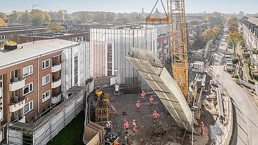 Veľký žeriav zdvíha komponent na stavenisku U5 v obytnej štvrti v Hamburgu