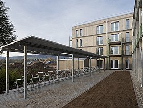 Foto von serieller Holzbauweise bei mehrgeschossigem Gebäude mit überdachtem Fahrradstellplatz