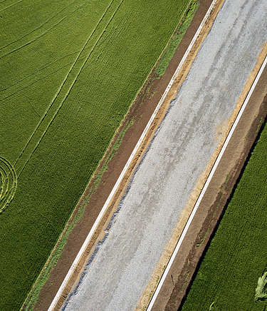 Straße führt zwischen Feldern hindurch.