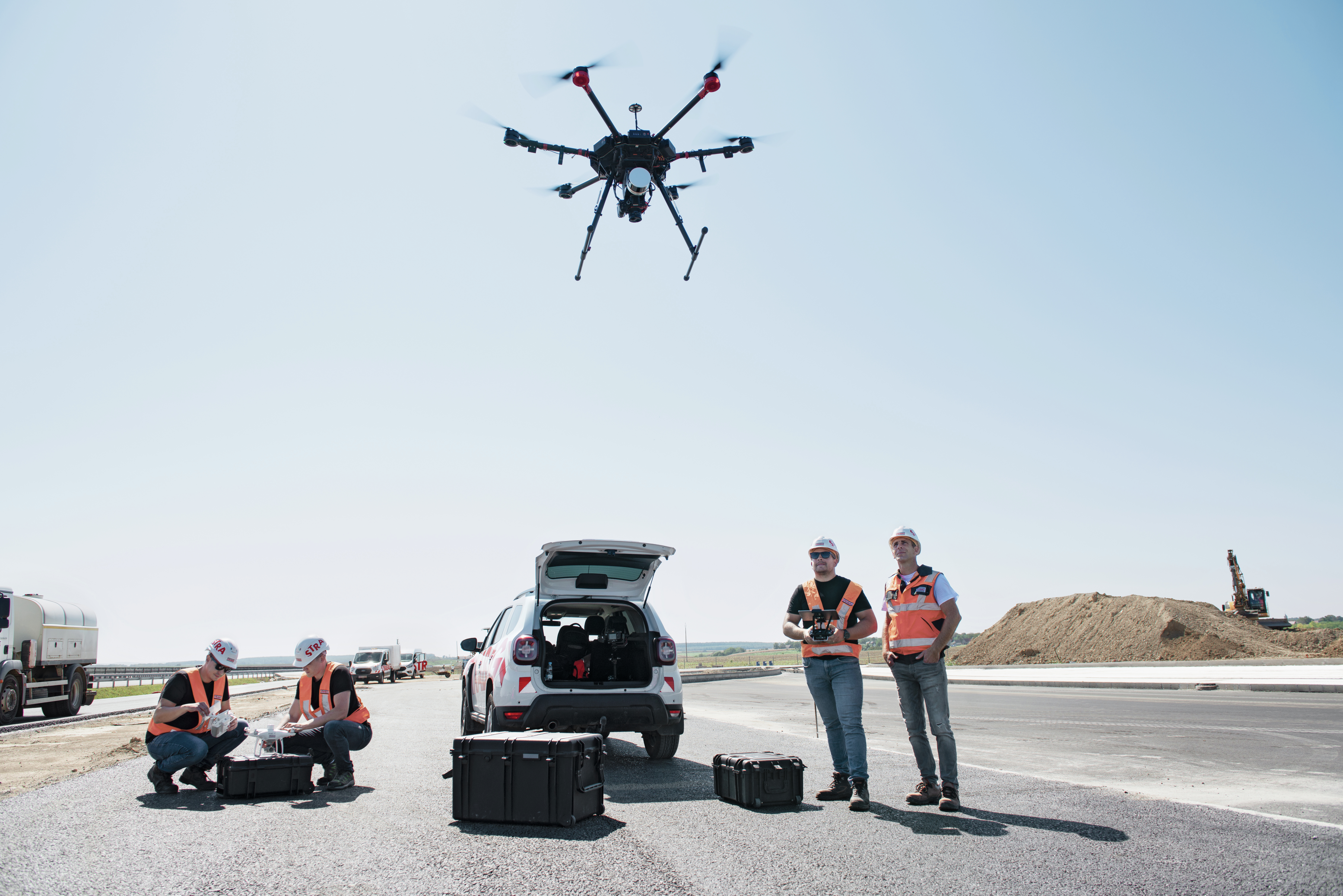 Photo of construction workers operating a drone