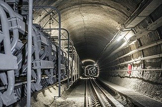 Tunnel with conveyor belt, track and pedestrian pathway