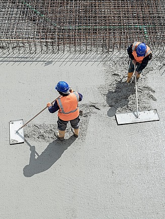 Dva pracovníci ukládající beton se sníženým obsahem CO2