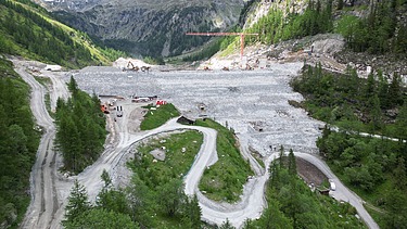 Aerial view of a quarry showing access roads, working areas and the surrounding mountainous landscape.