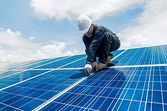 Instalace fotovoltaického systému na střeše budovy.